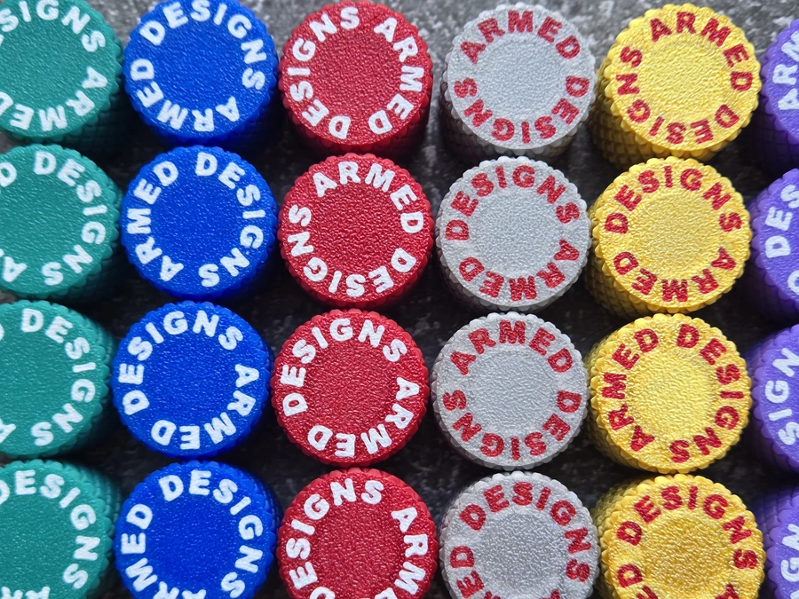 Colourful branded PLA threaded caps with knurled grip arranged in rows