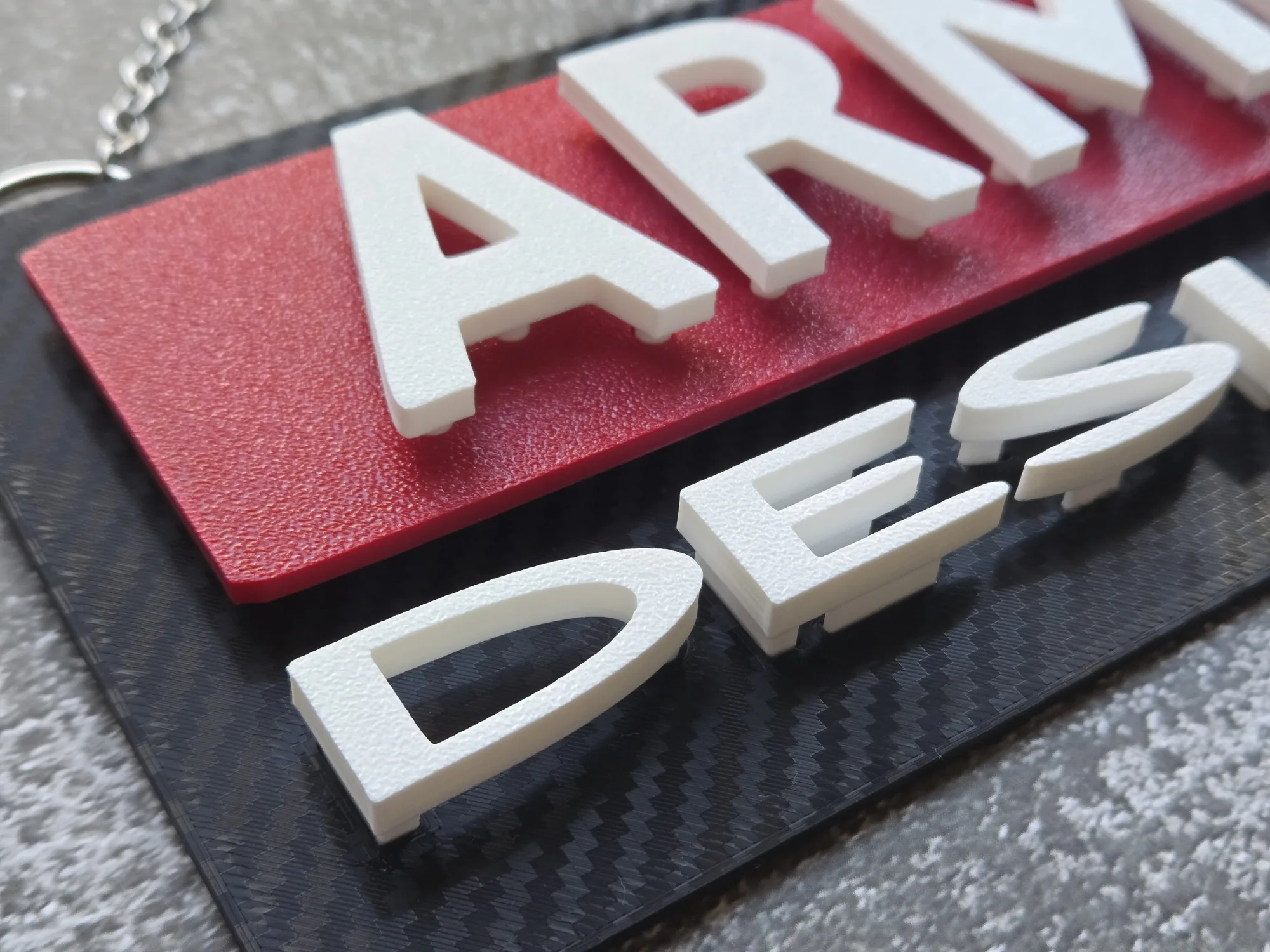 Close-up of the raised lettering and hidden mounting features on the ArmMed Designs sign.