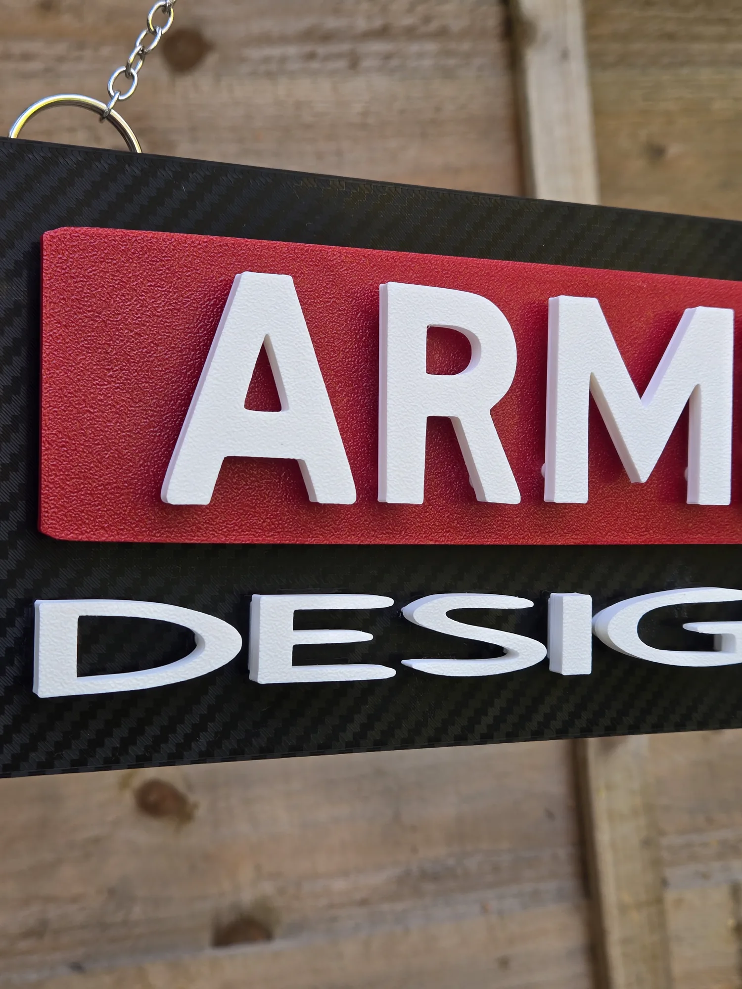 Close-up of the white 'DESIGNS' lettering on the ArmMed Designs sign.