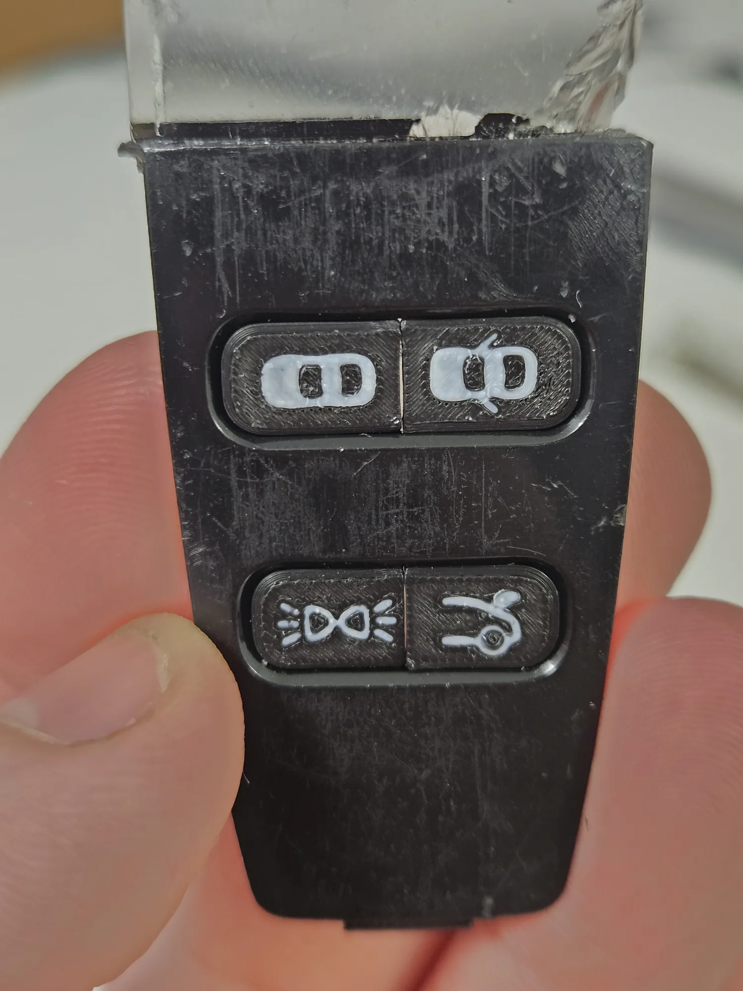Replacement buttons installed in the key fob, shown in hand.