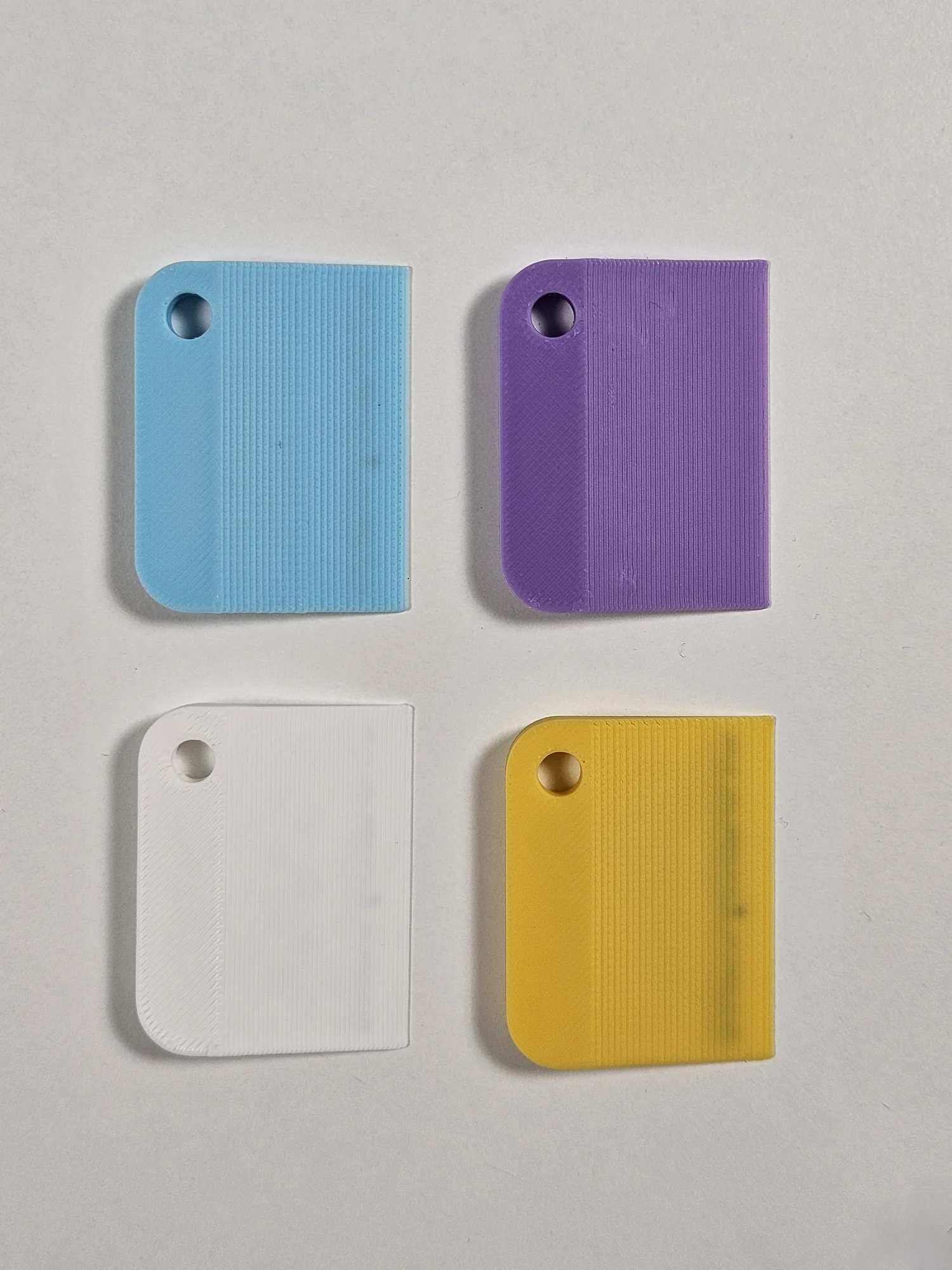 Four branded mini scrapers in different colours shown from the front.