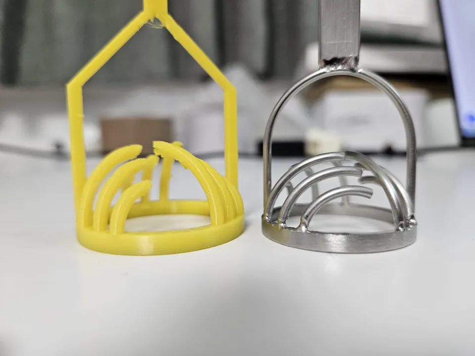 Yellow PETG tool and metal tool with their curved contact heads at table level.