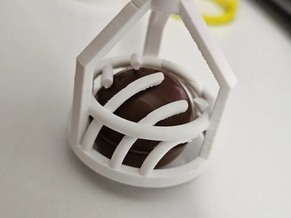 Close-up of the reinforced white PETG head and outer ring around a chocolate sample.