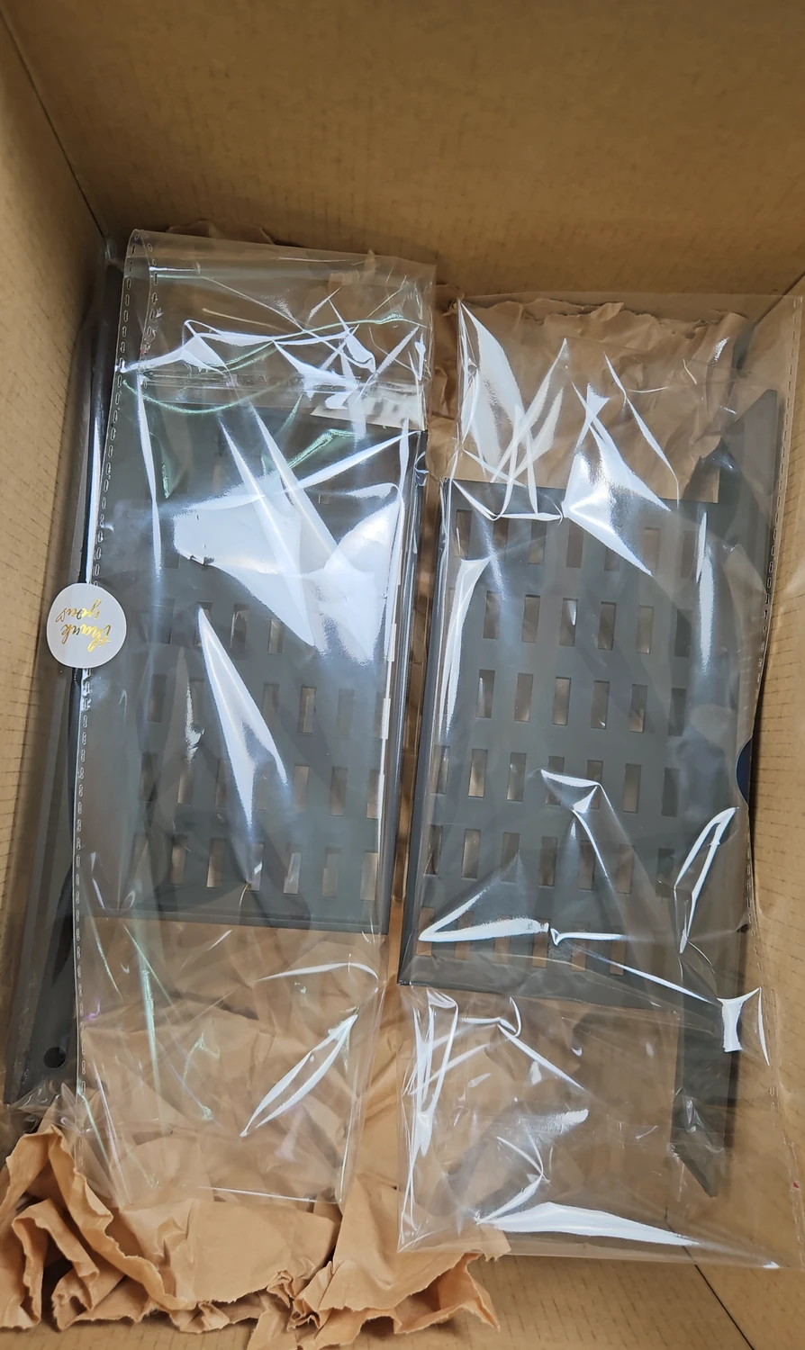 Two custom rack-mount adapters packed securely in a box.
