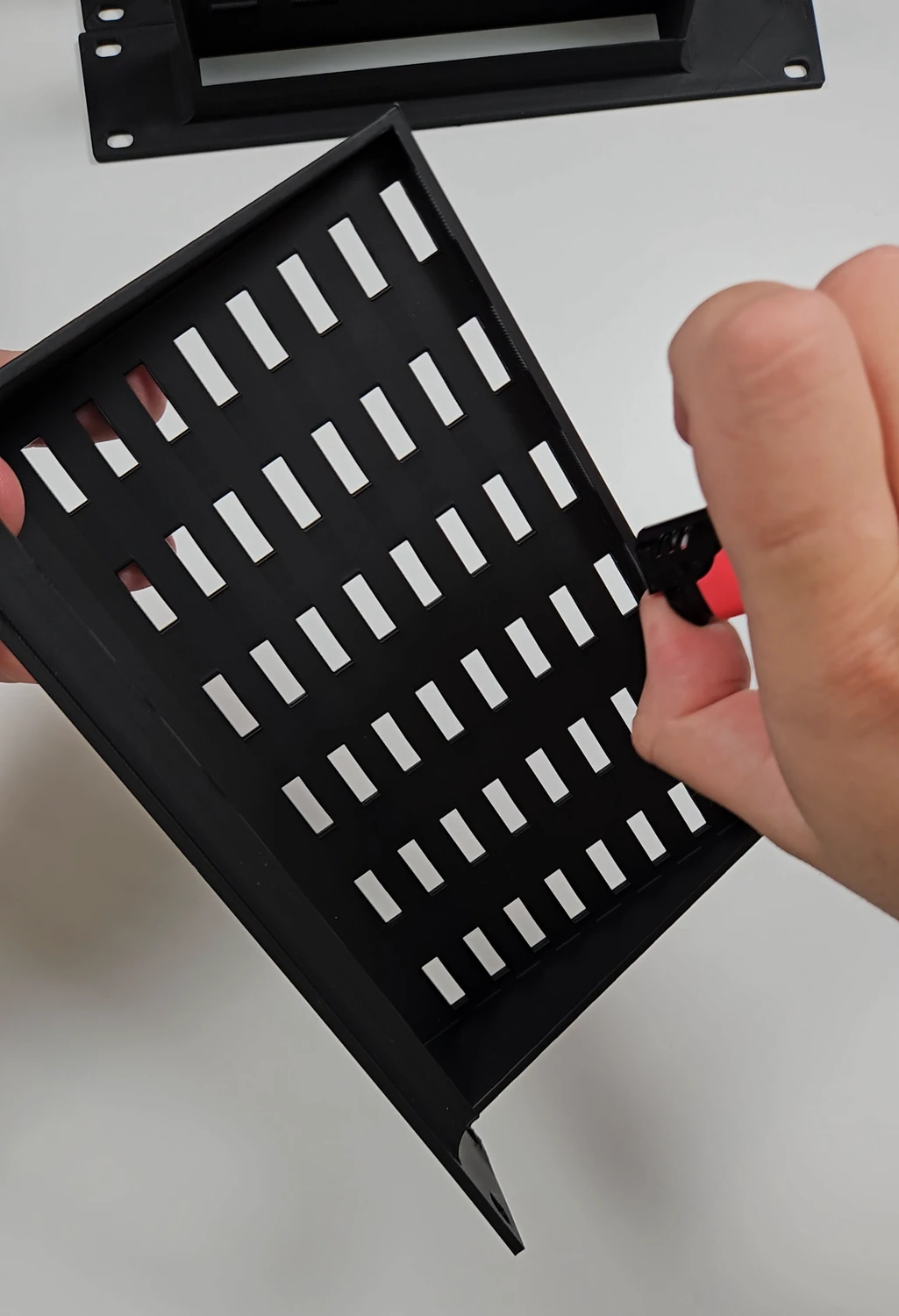 Removing fine stringing from a rack-mount adapter using a lighter during finishing.