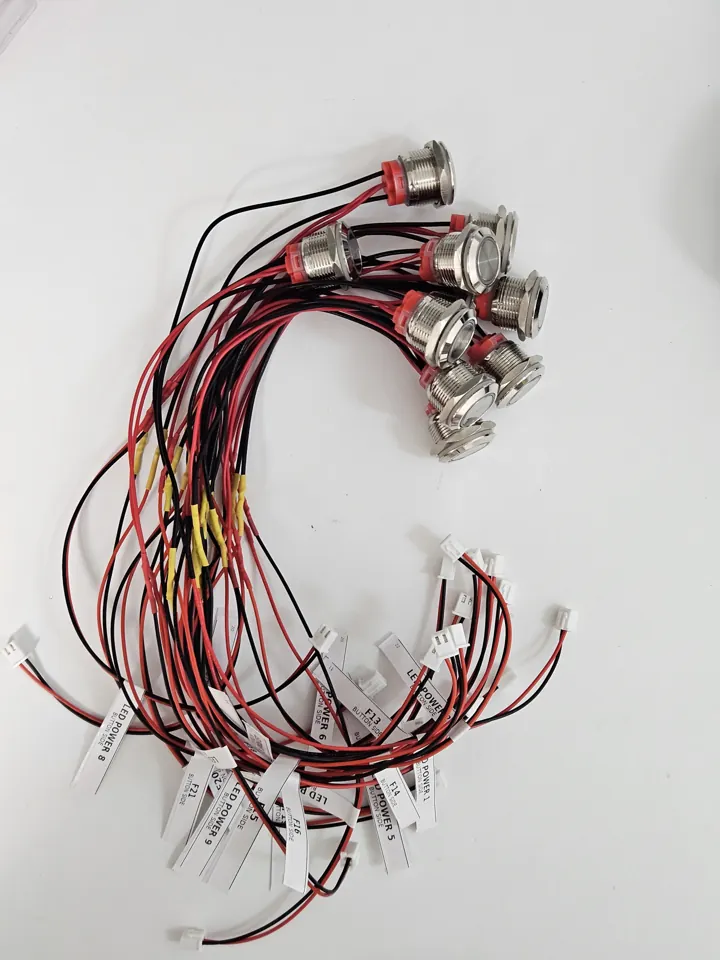 Bundle of wired metal buttons with individual connectors and printed labels.