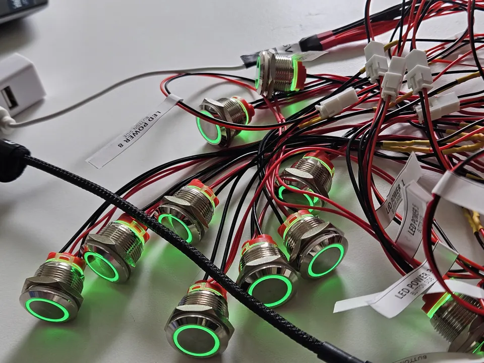 Green illuminated button rings during a bench wiring test.