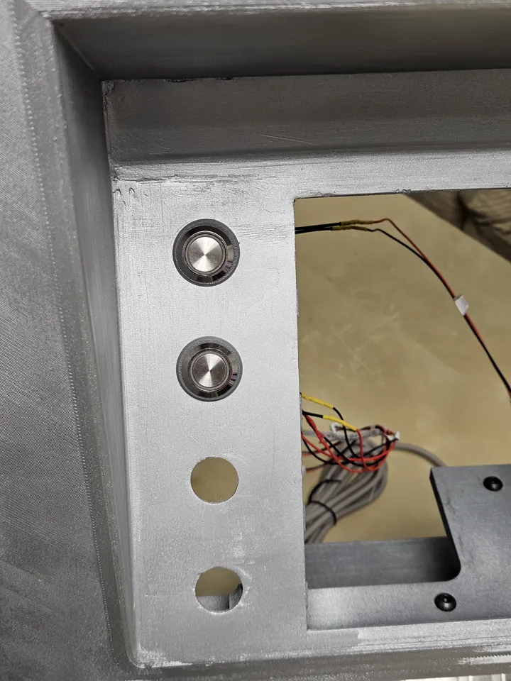 Metal buttons being installed down one side of the screen opening.