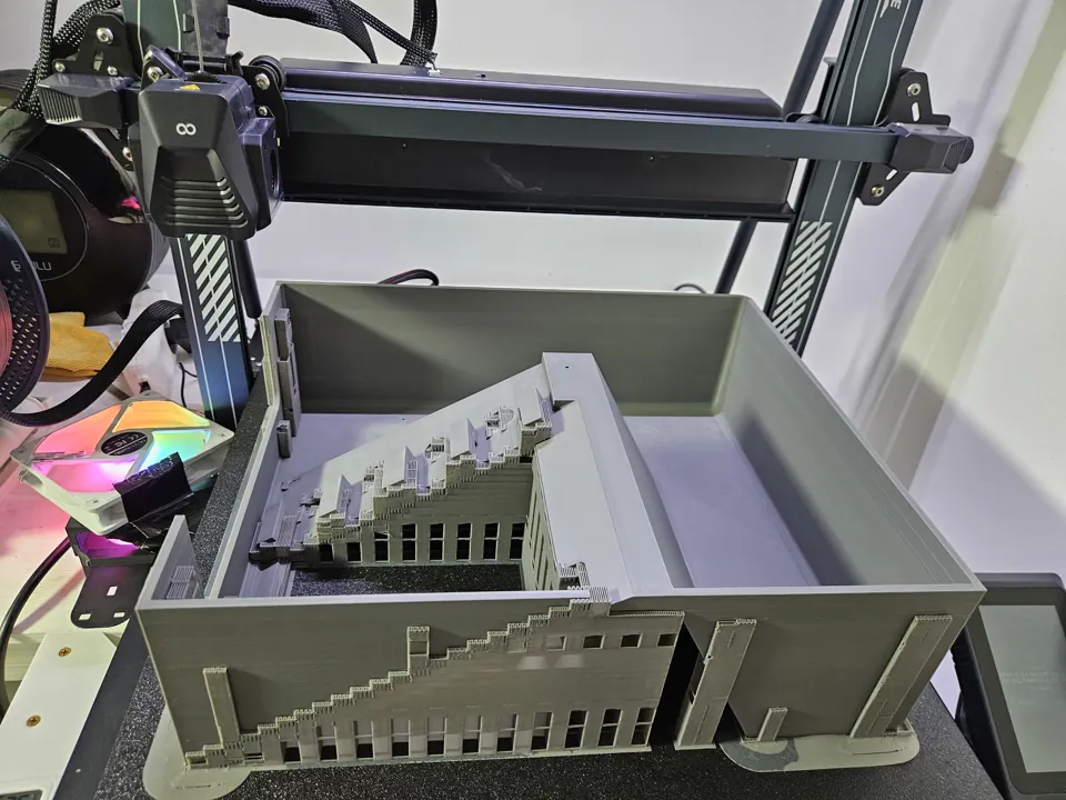 Large grey enclosure section on an open-frame printer with support structures around the screen recess.