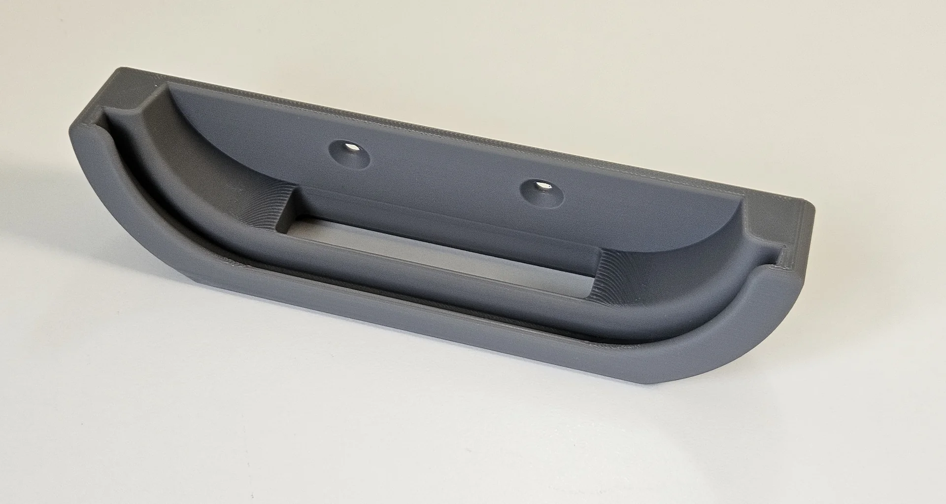 Grey printed Google TV Streamer 4K holder showing its curved cradle, fixing holes and cable opening.