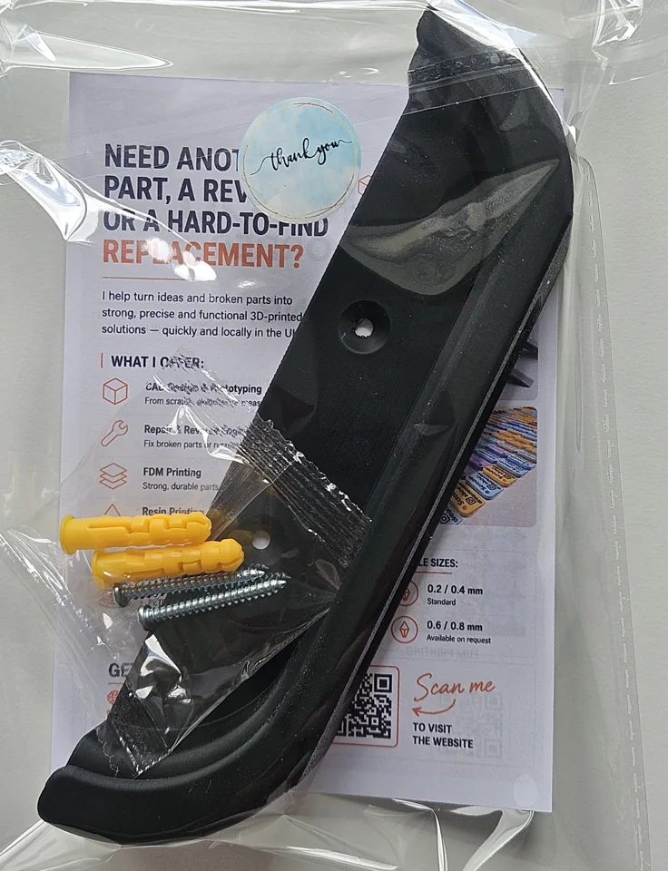 Black Google TV Streamer holder packaged with screws and yellow wall plugs.
