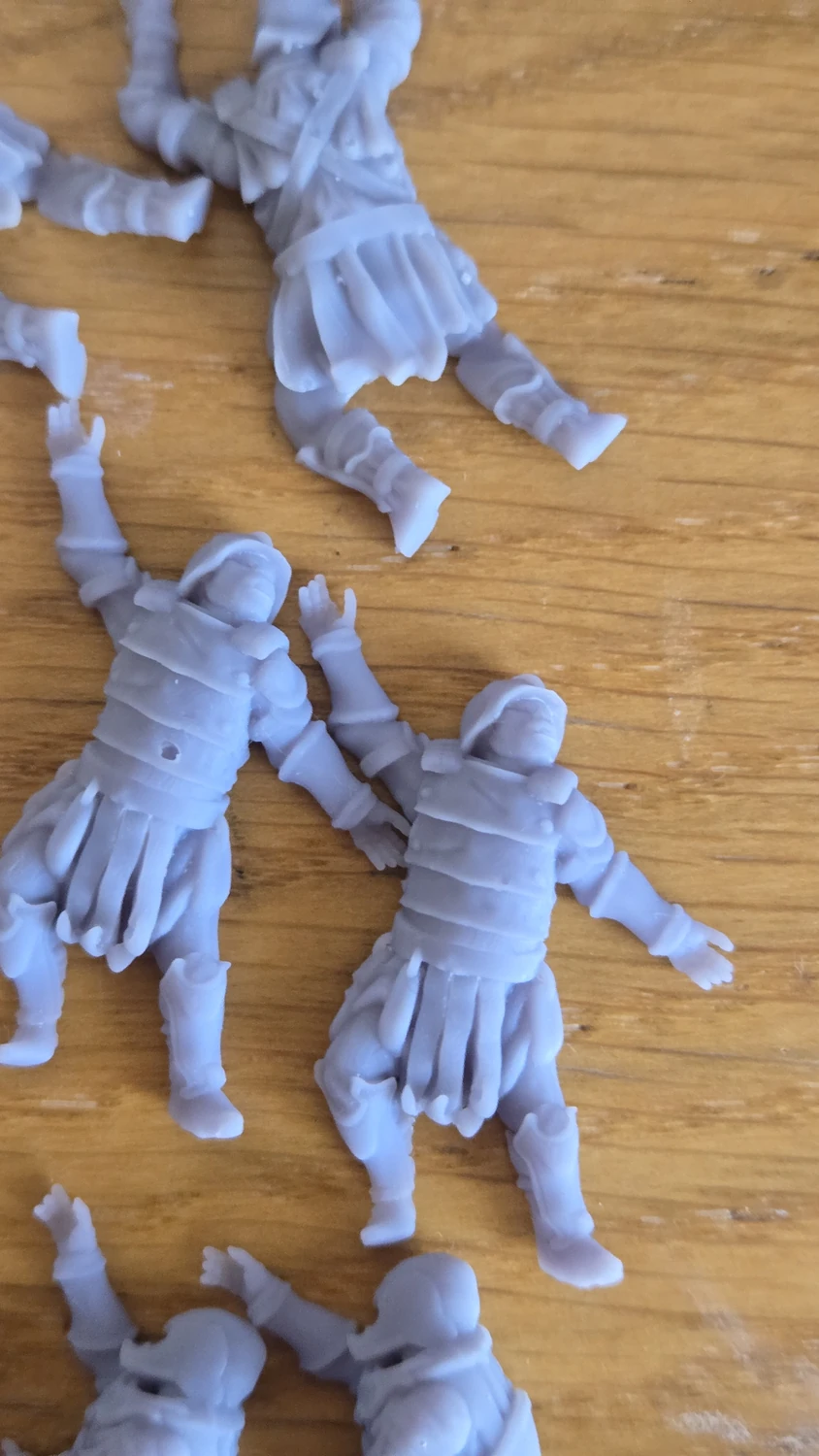 A group of small resin orc miniatures laid out together after printing.