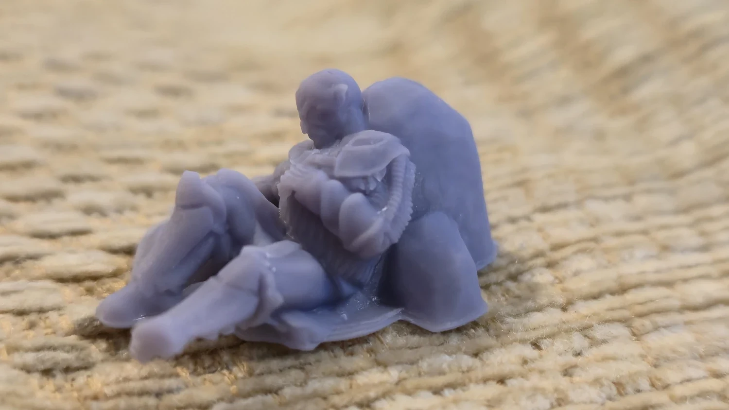 Small resin orc miniature resting on fabric after post-processing.