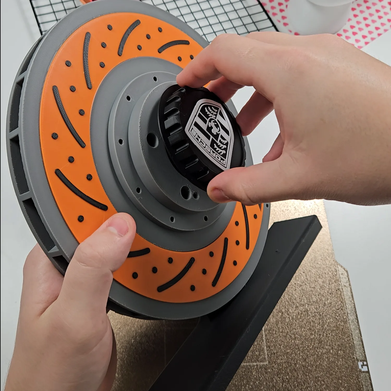 Fastening the personalised centre cap onto the assembled brake disc lamp on its stand.