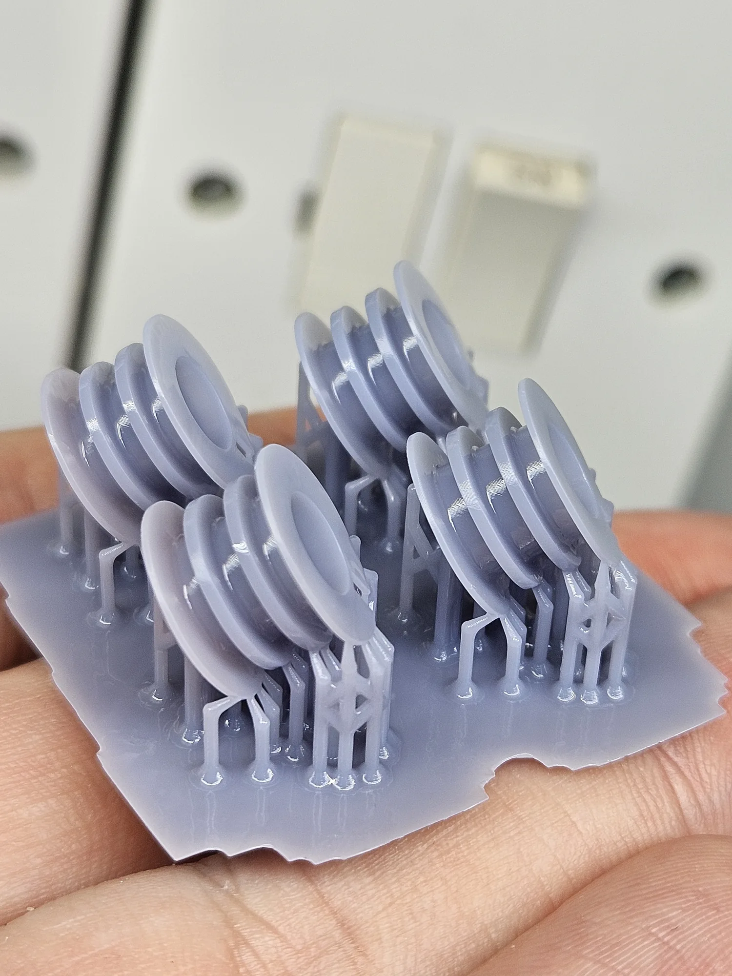 Round resin bobbins printed on supports before cleaning.