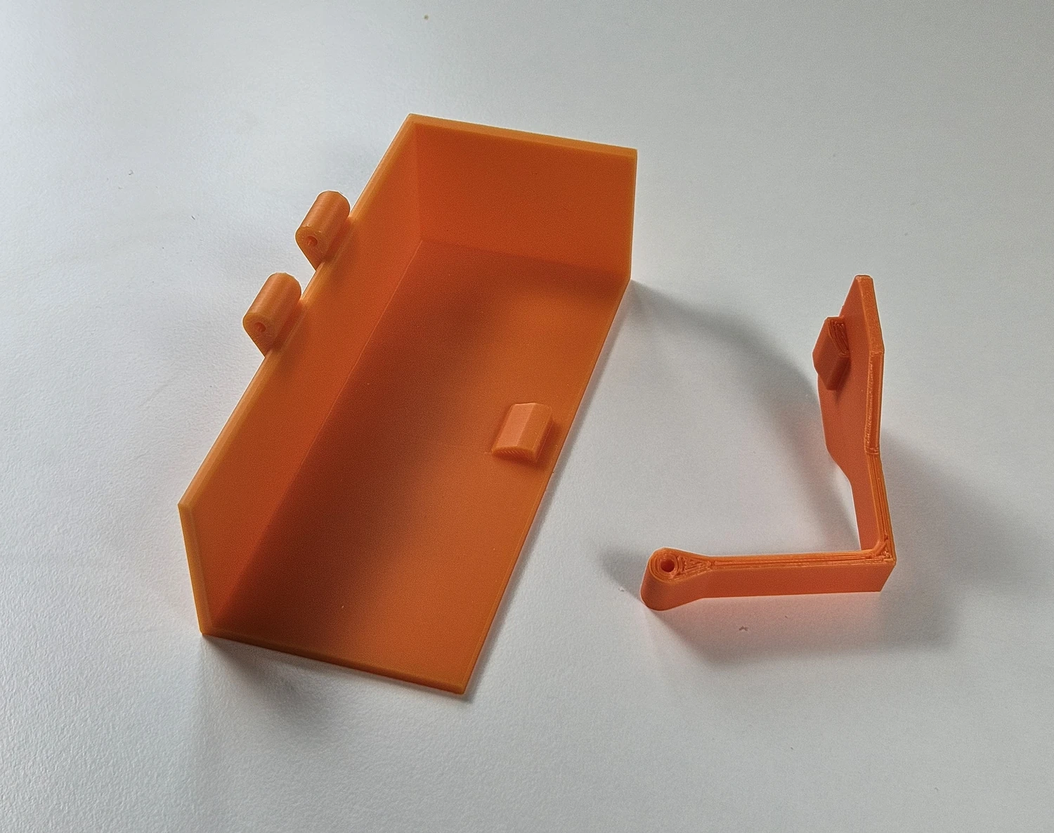 Two printed parts of the Ryobi battery removal tool laid out before assembly.