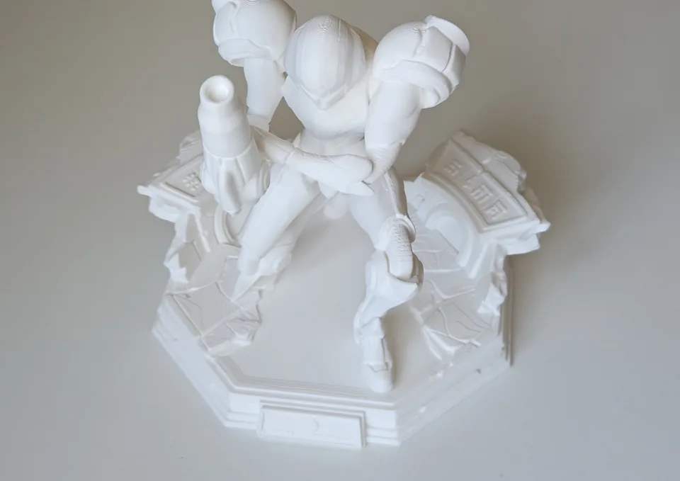 Angled view of the completed white statue and multi-level base.