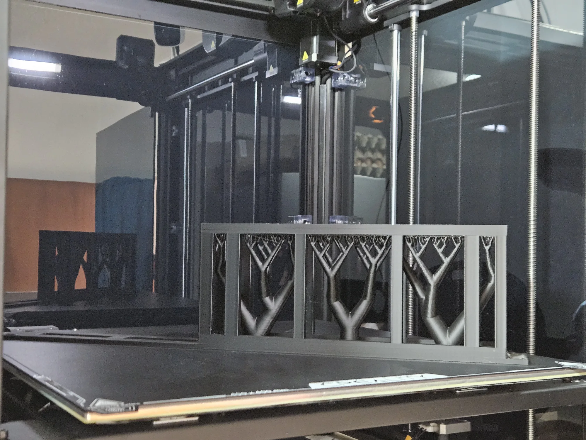 Long rack adapter positioned diagonally on the Creality printer bed, with supports beneath the basket openings.